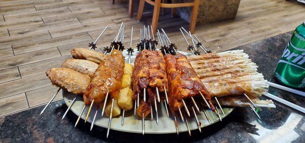 Lamb, chicken, spicy beef, fish tofu, bacon wrapped enoki, and chicken wing skewers