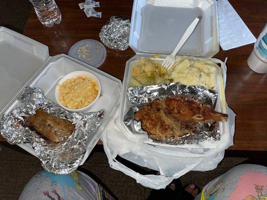 Pork chop plate with mashed potatoes and cabbage, and a slice of meat loaf with Mac and cheese.