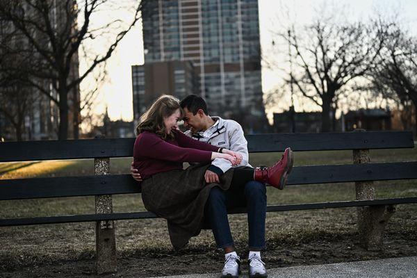 Intimate moment between interracial couple on a park bench.