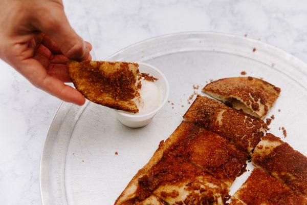 Enjoy a flaky slice of cinnamon sticks to dip in sweet icing!