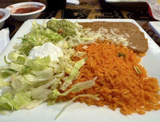 Sides plate of rice, beans, guacamole, and salad