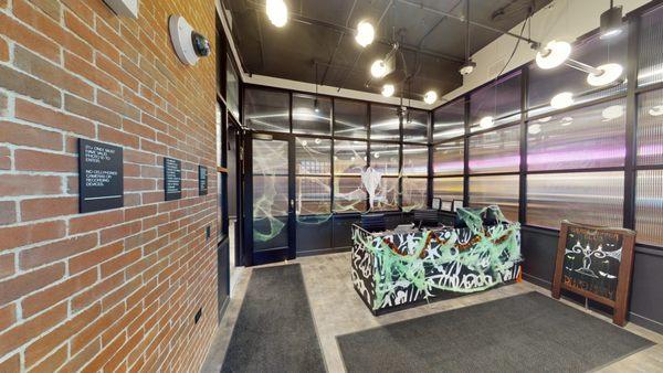 Inside a commercial space with exposed brick walls and a security camera mounted high on the left wall.