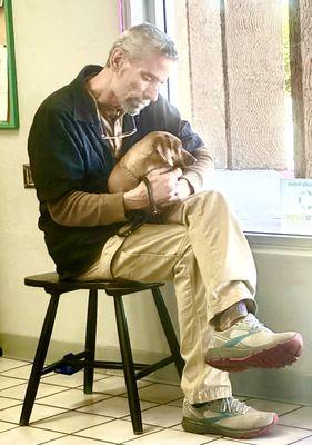 Owner Tim Mohr cuddling a pup waiting to be picked up from grooming.