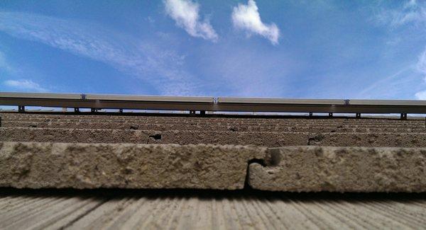 Flat Concrete Tile. Notice the gap between the tile and the array of solar panels. This allows for air circulation and cooling of the array.