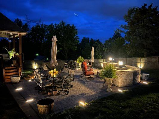 Outdoor living space built by the Living Hardscapes Contractor. The space boasts a large seating area with integrated lighting.