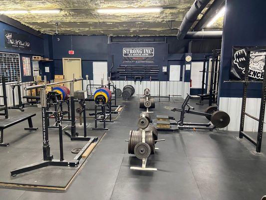 The powerlifting area at Strong Inc. Bench presses, squat racks, a pair of deadlifting stations, power racks, belt squat machine.