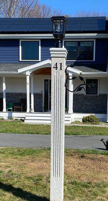 Granite lantern post with fluting and engraved numbers.