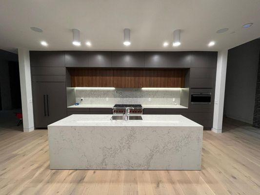 Modernism meets industrial minimalism in this kitchen remodel sporting custom cabinets and a huge island centerpiece