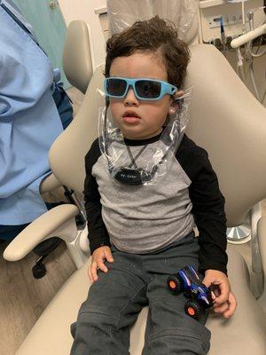 My 3 year old son wearing headphones, sunglasses, watching TV while "Lulu" and Dr. Corina worked their magic.