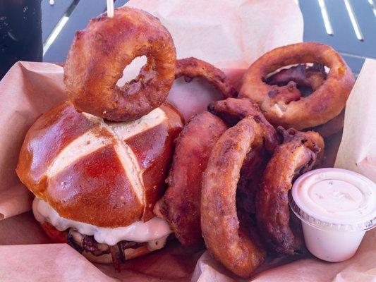 Burger of the month, with pretzel bun and onion rings.