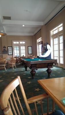 the dinning room has a pool table and arcade game