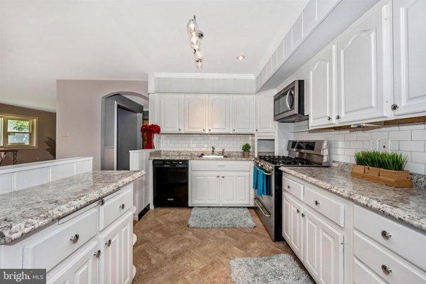 KITCHEN AFTER RENOVATION.  WALLS REMOVED ON LEFT, STOVE HOOD REMOVED AND REPLACED WITH A MICROWAVE.  REMOVED UGLY BACKSPLASH AND INSTALLED..