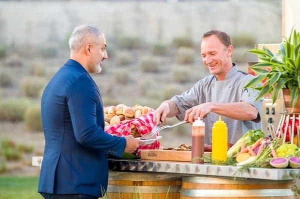 Executive Chef, Brad Martin, serving dinner to guests on the outside plaza for a Summer party.