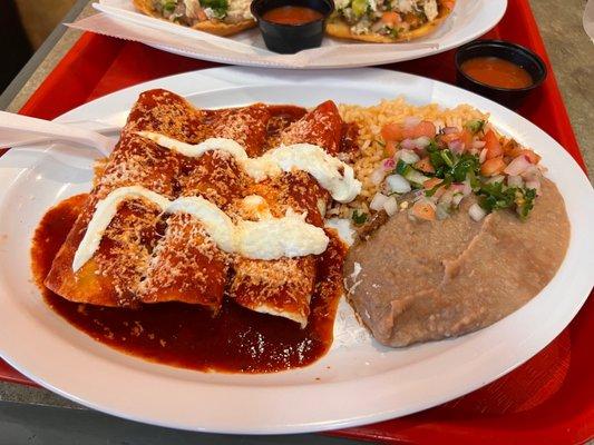 Enchiladas, rice and refried beans