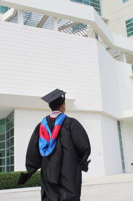 Graduate of an FAU master's degree program in front of the engineering building