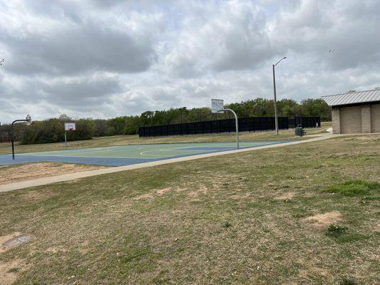 Basketball and tennis courts next to restrooms