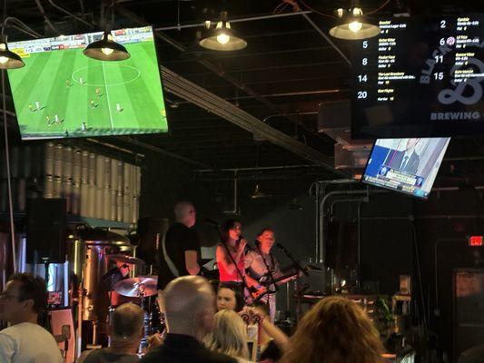 Live band playing on stage behind bar.