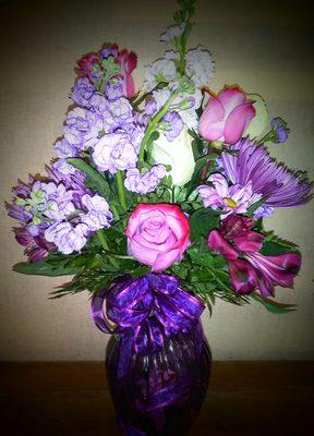 A beautiful array of assorted lavender flowers in a purple vase