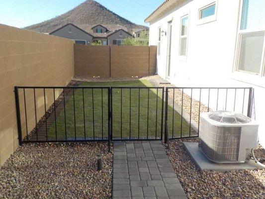 Dog run with real grass and custom metal gate and fence.