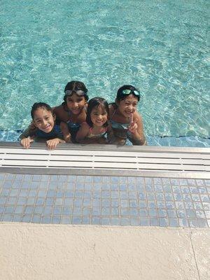 Ariela swimming in a public pool with my eldest daughter (to her left with the clear goggles on her head), Veronica, in August 2021.