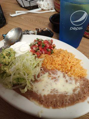 Beans, rice, veggies, sour cream, and guacamole that comes with the fajitas.