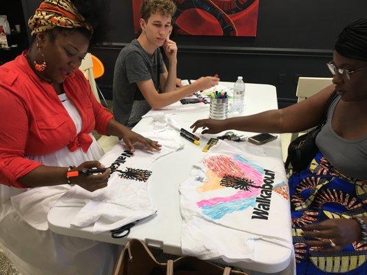 Creatives working on Art Walkabout Shirts in the gallery