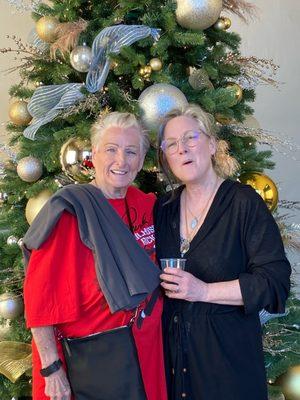 Sybil Poiset and Debra Bond in front of the Coronado Christmas tree inside.