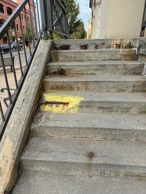 Large piece of cement missing from stairs going into hotel.