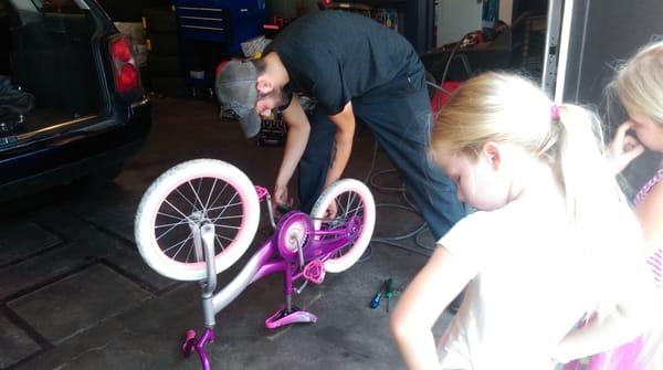 Ryan helping "Twins" Makayla and Olivia with their "Bicycle Maintenence"