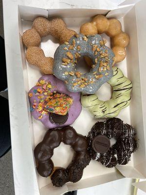 Cinnamon sugar, glazed, black sesame, ube fruity pebbles, matcha, chocolate, and cookies and cream mochi donuts.