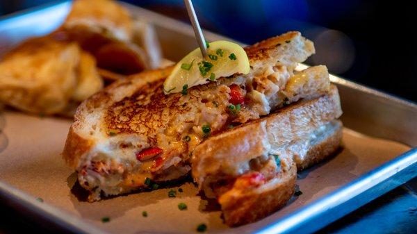 Lobster grilled cheese - our most popular dish!   Siracha, lobster, crab queso,  gouda on grilled sourdough.