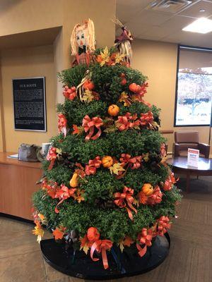 Current display a Fall season tree made with individual potted mums and scarecrows 9 2023