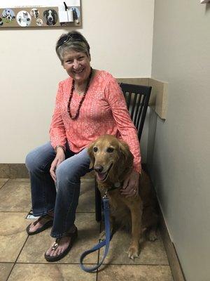 Carol and her Golden Retriever Bree in the exam room waiting for the veterinarian to examine Bree's paw.