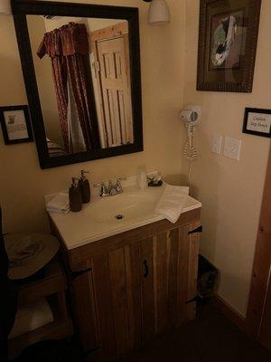 Bathroom sink located outside of restroom with full sized pump of hand soap and lotion.