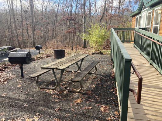 The outside of stoneybrook cabin. It is wheelcchair accessible, has a grill, extra long picnic table, and extra tall fire ring.