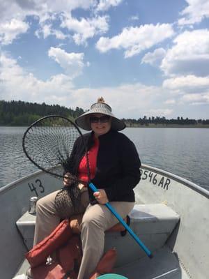 Julie in the boat on big lake. Started out warm and sunny. Ended cold stormy and windy. Great trout!