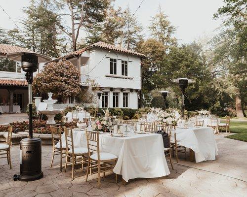 An outdoor reception space set up with long tables.