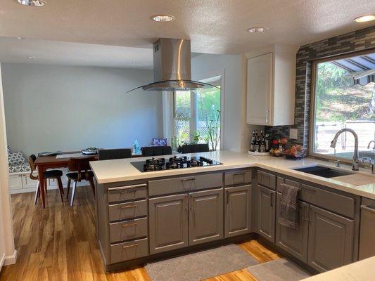 Kitchen: removed existing wall and hanging cabinet, repainted existing cabinets and installed island ventilator