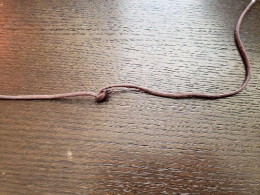 Broken shoelace, tied in a knot.