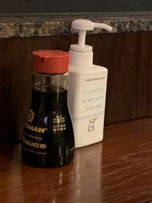 The set up on table of soy sauce and hand sanitizer.