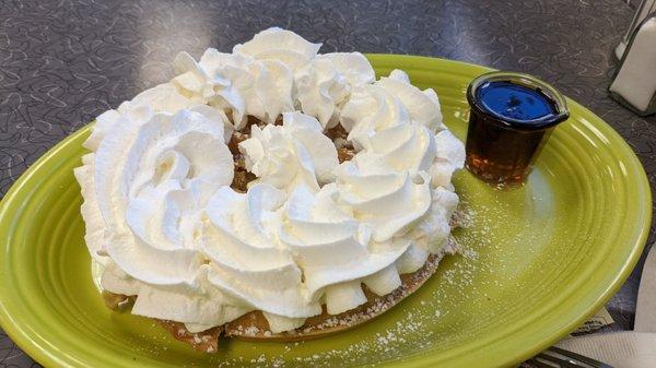 Waffle with butter, powdered sugar, and whipped cream