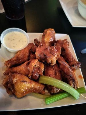 Smoked bone-in wings with garlic buffalo dressing and a side of ranch dipping sauce and celery