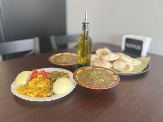 Foul (Fava bean) plates with breads and veggies.