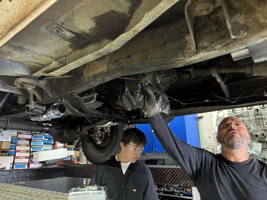 Jesse doing a fine job with Mario installing my new exhaust system.