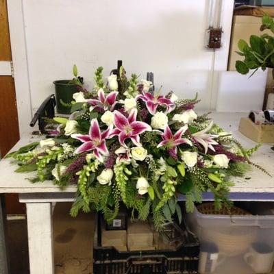 Casket piece of white roses, stargazer lilies, snapdragons and white veronica and beautiful heather.