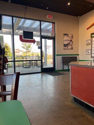 Inside of store showing outdoor table to enjoy meal .