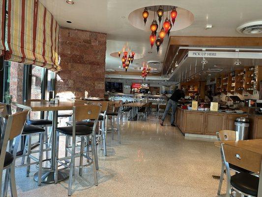 Panevino Deli counter with food, high top and regular table seating.