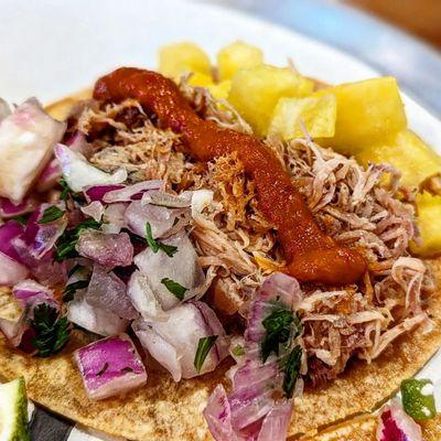 Carnitas: Slow Roasted Pork Carnitas Topped with Fresh Pineapple, Diced Red Onion and Fermented Hot Sauce.