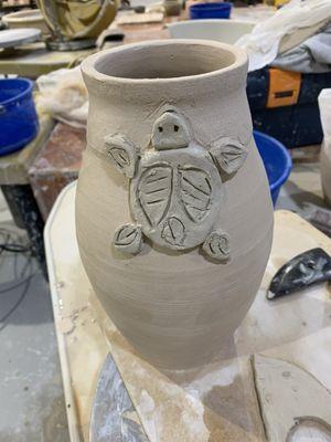 Hand building on a pot I made. Adding sculpture to my new pot.