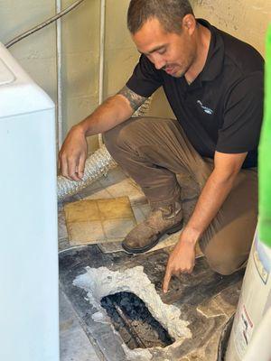 Sonny pointing at a slab leak after exposing it in a house in St. Petersburg.